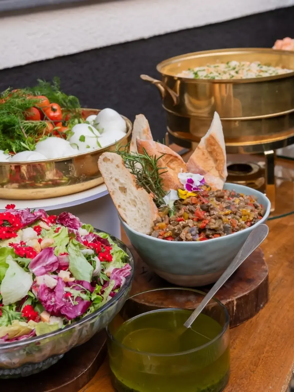 Saladas, pães e antepastos apresentados à mesa