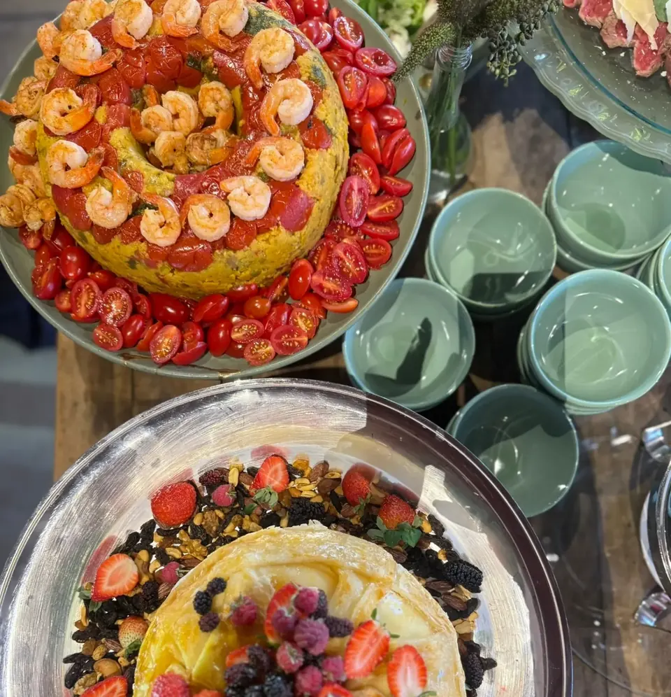 Pratos com camarões, tomates, queijo e frutas