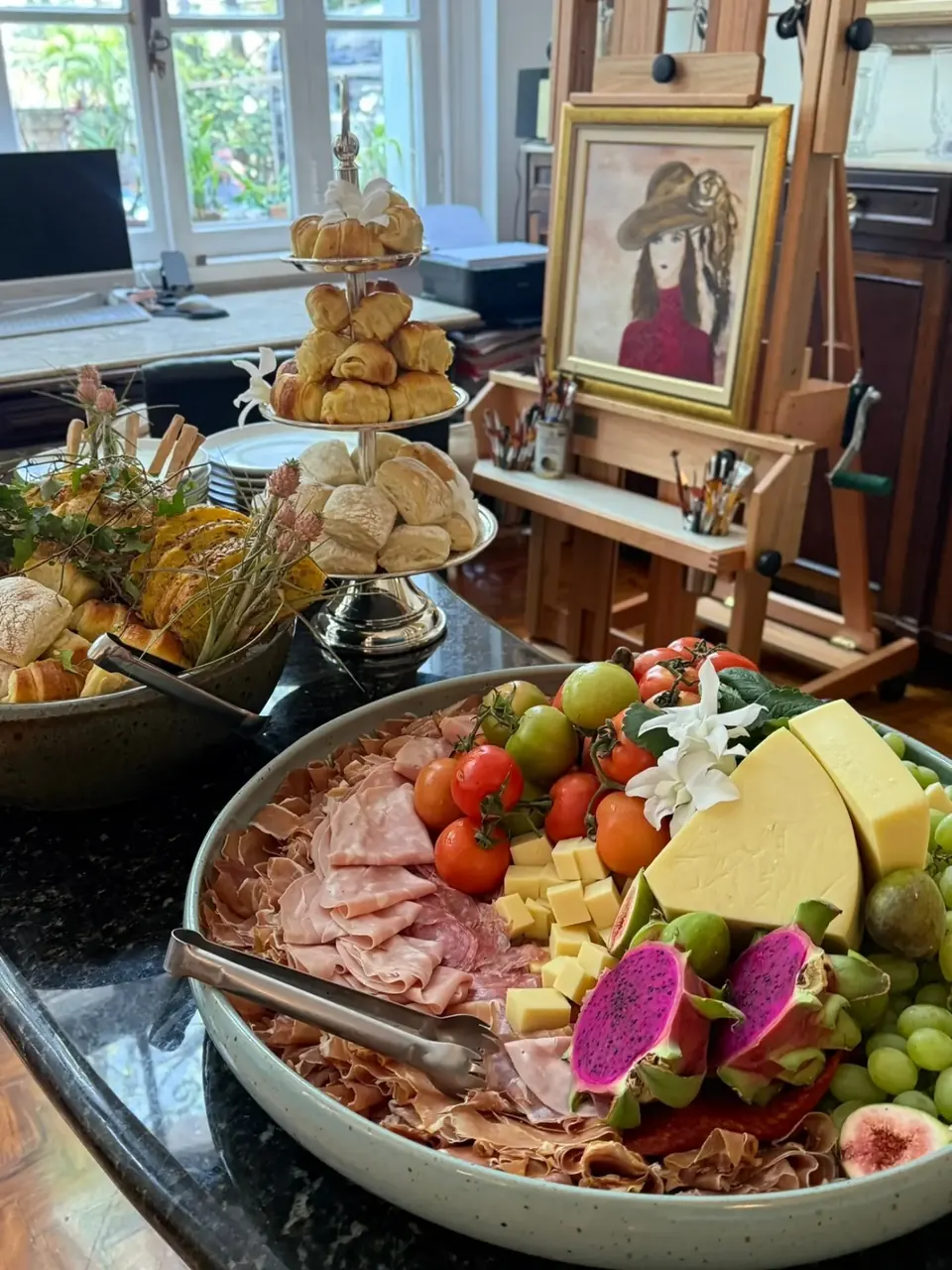 Queijos, frios, frutas e pães em uma mesa de recepção