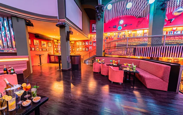 Lado esquerdo do mezanino com lounges, mesas e decoração musical